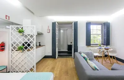 a living room with a couch and a table at Papa 1T · Papa Studio Central Garden View in Porto