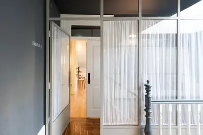 a room with a glass door and a hallway with a table at Habitat137 in Porto