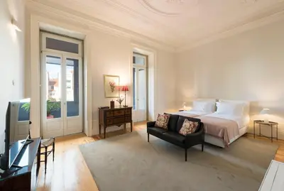 a bedroom with a bed and a couch and a television at Habitat137 in Porto