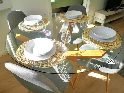 a glass table with chairs and plates on it at OportoView Prestige Apartment in Porto