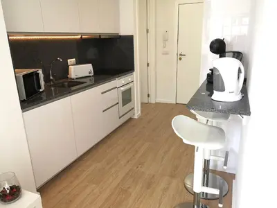 a kitchen with white cabinets and a counter top at OportoView Prestige Apartment in Porto