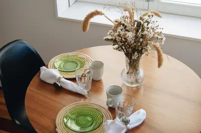 a wooden table with green plates and a vase of flowers at Oxford Green House by LovelyStay in Porto