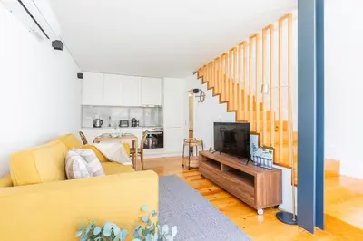 a living room with a blue couch and a tv at Heroismo Duplex Terrace in Porto