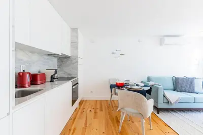 a kitchen with white cabinets and red appliances at Heroismo Duplex Terrace in Porto