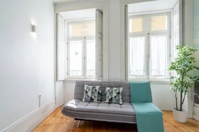a living room with a couch and two windows at Host Wise - Homely Noble Flats - Garden & Jacuzzi in Porto