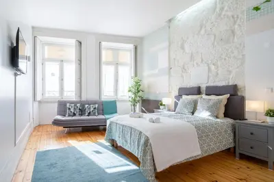 a bedroom with a king sized bed and a couch at Host Wise - Homely Noble Flats - Garden & Jacuzzi in Porto