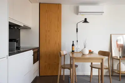a kitchen with a wooden table and a small table and chairs at Box Market Square Apartment in Porto