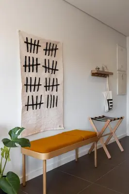 a bench in a room with a blanket with kanjiletters on it at Box Market Square Apartment in Porto