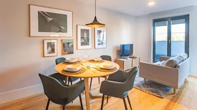 a living room with a dining room table and chairs at Stylish Studio w/ AC & Balcony by LovelyStay in Porto