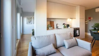 a living room with a couch and a kitchen at Stylish Studio w/ AC & Balcony by LovelyStay in Porto