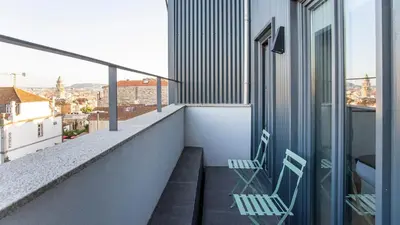 two chairs on a balcony with a view of a city at Stylish Studio w/ AC & Balcony by LovelyStay in Porto