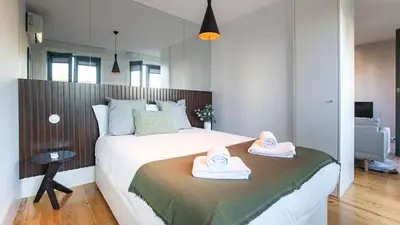 a bedroom with a bed with two towels on it at Stylish Studio w/ AC & Balcony by LovelyStay in Porto