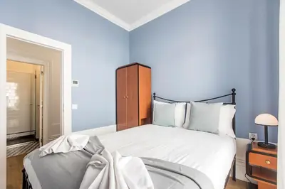 a bedroom with a large bed with blue walls at Artistic 2BR Flat Downtown w/ AC by LovelyStay in Porto