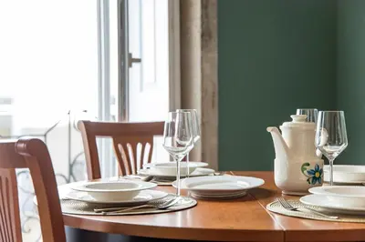 a wooden table with plates and wine glasses on it at Artistic 2BR Flat Downtown w/ AC by LovelyStay in Porto