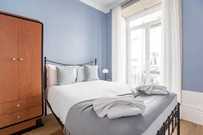 a bedroom with a bed with blue walls and a window at Artistic 2BR Flat Downtown w/ AC by LovelyStay in Porto