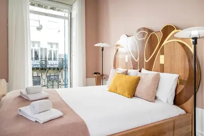a bedroom with a large bed with two towels on it at Artistic 2BR Flat Downtown w/ AC by LovelyStay in Porto