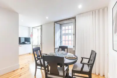 a dining room with a table and four chairs at Elegant Downtown 1BR Flat w/ AC by LovelyStay in Porto