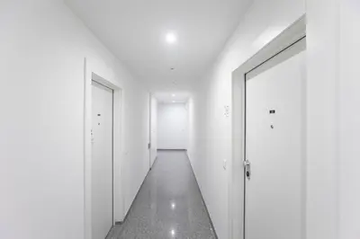 an empty hallway with white walls and a door at Elegant Downtown 1BR Flat w/ AC by LovelyStay in Porto