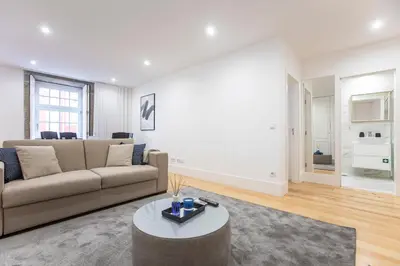 a living room with a couch and a table at Elegant Downtown 1BR Flat w/ AC by LovelyStay in Porto