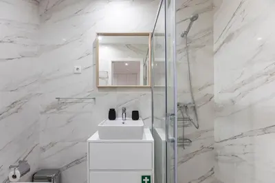 a white bathroom with a sink and a mirror at Elegant Downtown 1BR Flat w/ AC by LovelyStay in Porto