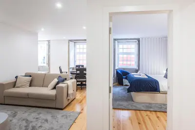 a bedroom and a living room with a bed and a couch at Elegant Downtown 1BR Flat w/ AC by LovelyStay in Porto