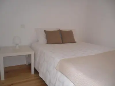 a bedroom with two beds and a night stand with a table at YOUR PLACE PORTO I in Porto