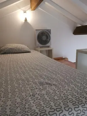 a bedroom with a bed with a fan on the wall at YOUR PLACE PORTO I in Porto