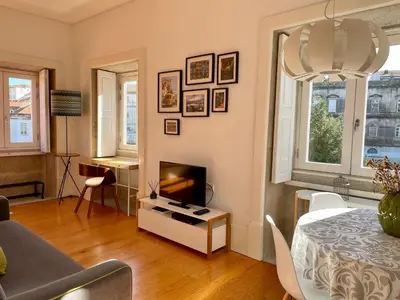 a living room with a table and a tv in it at Santo António Charming Flat in Porto