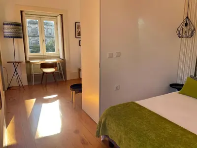 a bedroom with a bed and a window and a desk at Santo António Charming Flat in Porto