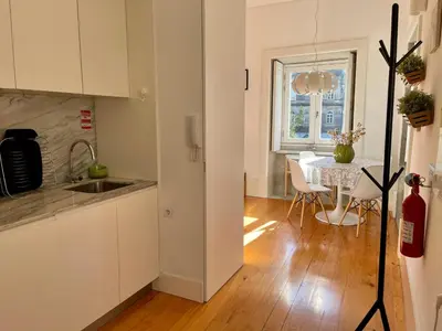a kitchen and dining room with a table and a window at Santo António Charming Flat in Porto