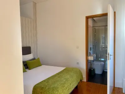 a bedroom with a bed and a bathroom at Santo António Charming Flat in Porto