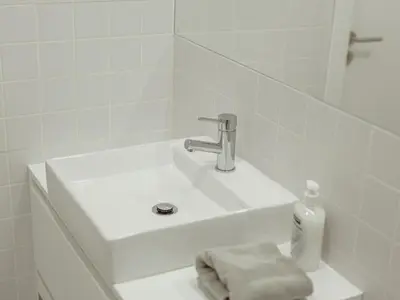 a white sink in a bathroom with a bottle of soap at OPORTO GUEST Poveiros Home in Porto