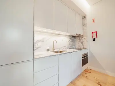 a white kitchen with white cabinets and a sink at OPORTO GUEST Poveiros Home in Porto