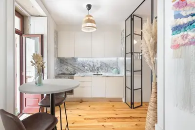 a kitchen with a table and chairs in a room at Vibrant flat by São Bento w/balcony - Loureiro140 in Porto