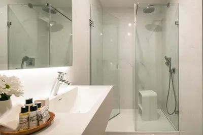 a white bathroom with a shower and a sink at Porto River Infante in Porto