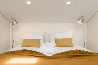 a white bed with two towels on top of it at Center Liberty Apartment in Porto