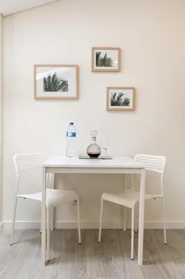 a white table with two chairs and two pictures on the wall at Center Liberty Apartment in Porto