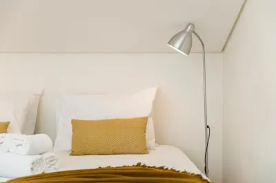 a white bedroom with a bed with a lamp at Center Liberty Apartment in Porto