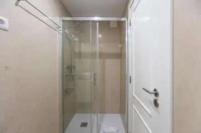 a shower with a glass door in a bathroom at City Center 2BR Flat w/ AC by LovelyStay in Porto