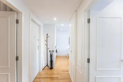a hallway with white walls and a hard wood floor at City Center 2BR Flat w/ AC by LovelyStay in Porto
