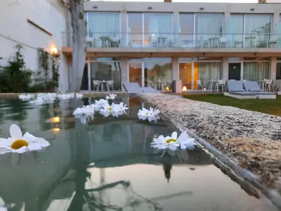 a pool of water with white flowers in front of a building at Oca Vitoria Village in Porto