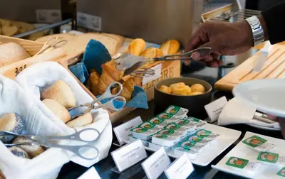 a person holding a pair of scissors over a table with food at Oca Vitoria Village in Porto