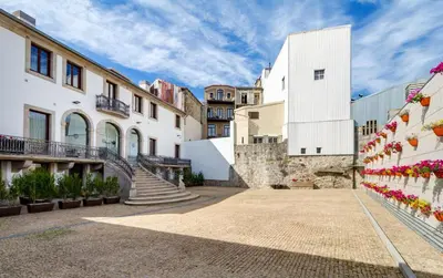 a courtyard of buildings with stairs and flowers at Oca Vitoria Village in Porto
