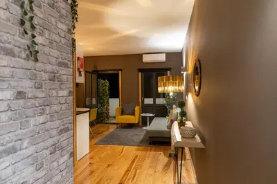 a hallway with a brick wall and a living room at Rolé Douro - Almada 340 in Porto