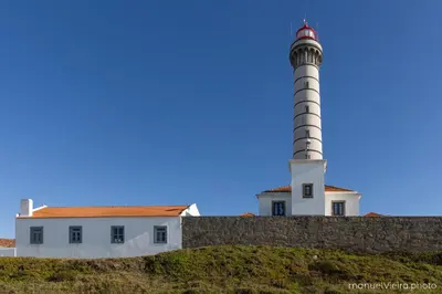 a lighthouse on top of a wall next to a building at Rolé Douro - Almada 340 in Porto