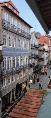a bed in the corner of a room with a couch at PORTO DOWNTOWN Rua das FLORES in Porto