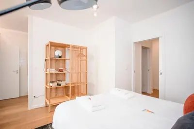 a white room with two beds and a book shelf at Liiiving in Porto - Ribeira Vintage View in Porto