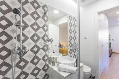 a bathroom with a shower and a toilet and a sink at Homely Studio w/ AC near Marquês by LovelyStay in Porto