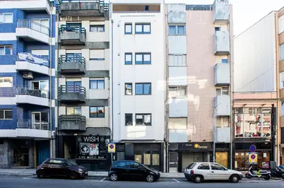 a tall white building with cars parked in front of it at Homely Studio w/ AC near Marquês by LovelyStay in Porto