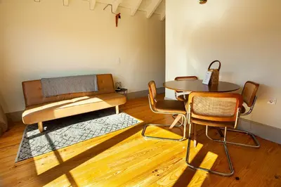 a living room with a table and chairs and a couch at Oporto City View- Trindade Lovely in Porto
